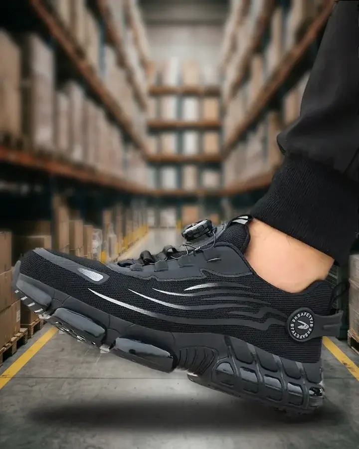 Zapatilla WorkArmor negra en un pasillo de almacén entre estanterías de palés